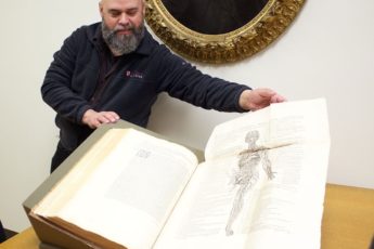 Drew Bourn shows students a first-edition copy of De humani corporis fabrica, written in 1543 by Flemish anatomist-physician Andreas Vesalius
