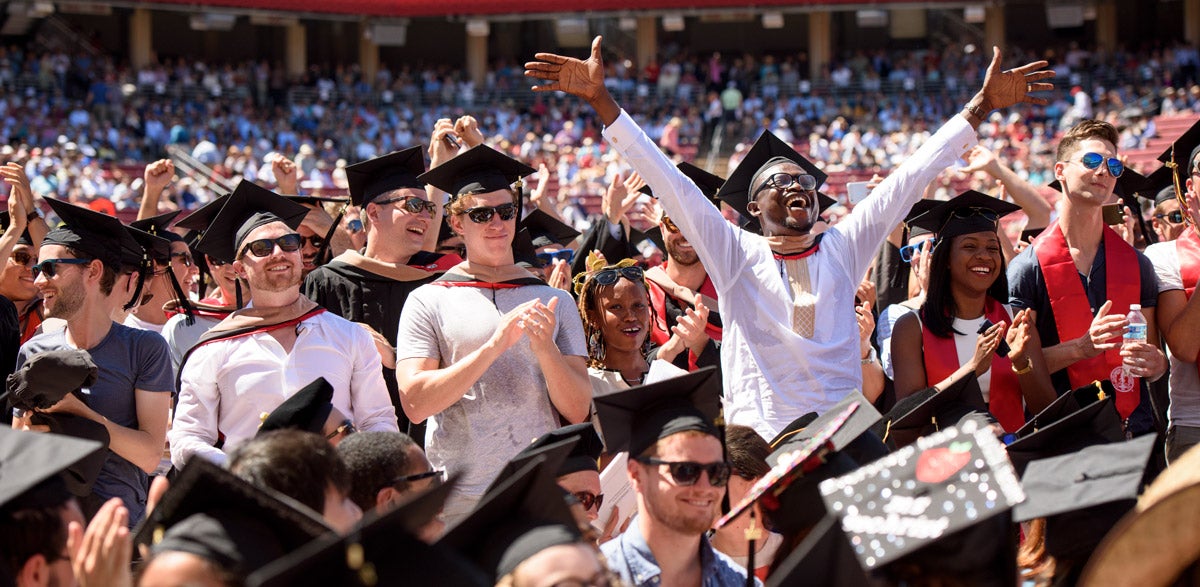 Students from the Graduate School of Business rise to receive their conferral of degrees.