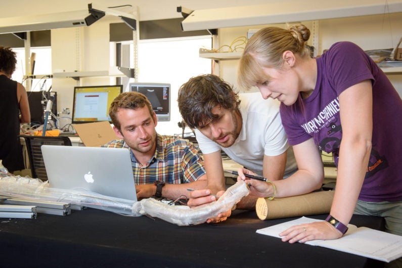 Graduate students Joseph Greer, left, and Laura Blumenschein, right, work with Elliot Hawkes, a visiting assistant professor