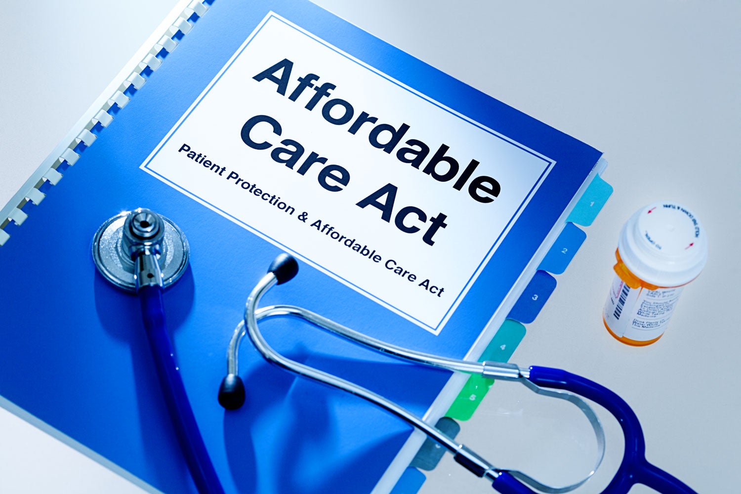 photo of a binder titled Affordable Care Act with stethoscope, pill bottle