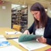 Claire Dunning in the library examining old government training manual