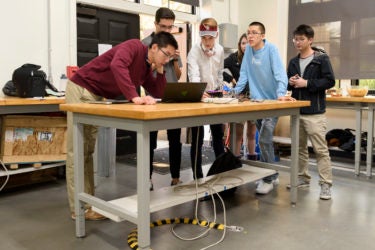 Students test each other's devices at the freshman haptics class open house.
