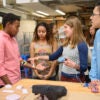 Senior Moses Swai, left, gets a demonstration from Jabreea Johnson, Charlotte Peale, and Johnny Armenta who developed a Foot Haptic device.