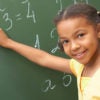 happy girl doing math at chalkboard