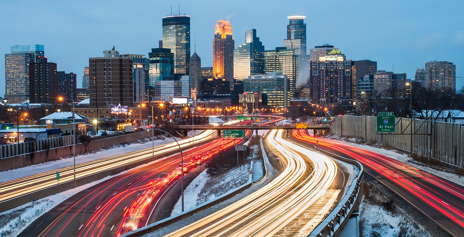 Heavy traffic flowing in and out of Minneapolis on Interstate 94 just after sunset, on a winter evening.
