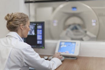 Doctor operating CT scanner in hospital