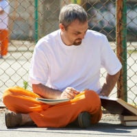 Man reading books at prison yard