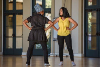 Dance lecturer Aleta Hayes, left, coaches a student in her presentation.