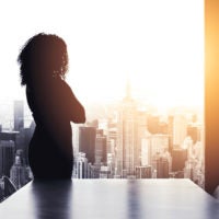 Silhouette of woman standing alone in boardroom