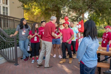 Pilli Cruz-DeJesus is greeted by Stanford President Marc Tessier-Lavigne and the staff of Muwekma-Tah-Ruk, the Native American theme house.