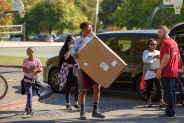 Freshman Yosheb Getachew of Parker, Colorado, carries some of his belongings to his dorm.