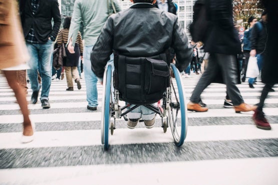 Wheelchair user from behind in a busy pedestrian zone
