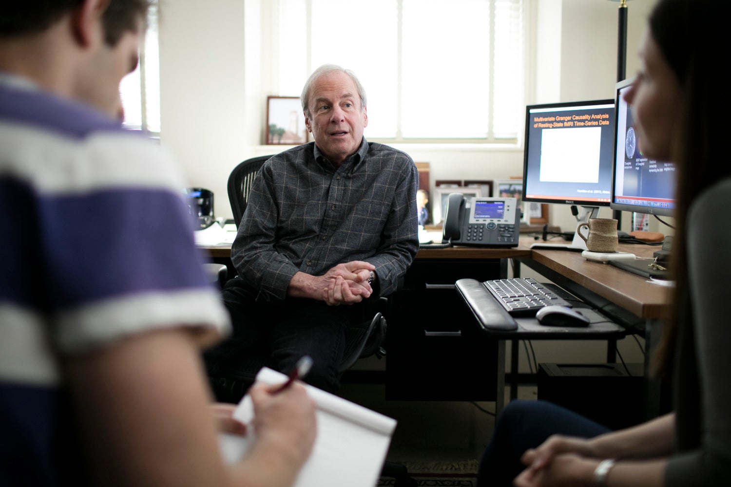 Psychology professor Ian Gotlib confers with students in his office.