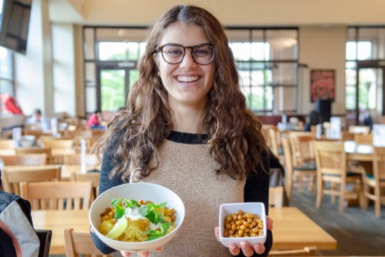 Student Coraal Cohen holding dishes of food.