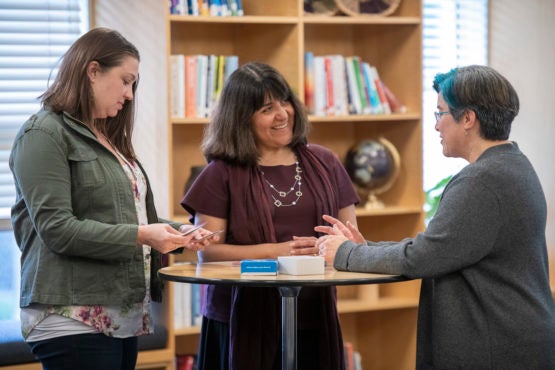Laura Dominguez Chan, center, a 2019 Amy J. Blue Award recipient, works with Colleen McCallion, left, and Margot Gilliland.