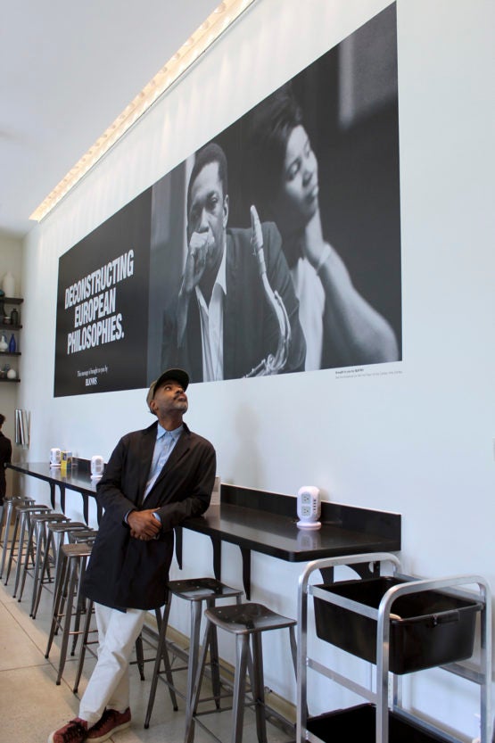Artist Kahlil Joseph pauses in front of a BLKNWS poster in the Cantor Café.