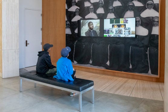 Visitors at Stanford’s Cantor Arts Center absorb the video images from Kahlil Joseph’s BLKNWS, 2018.