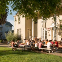 Students sitting at tables outside residence.