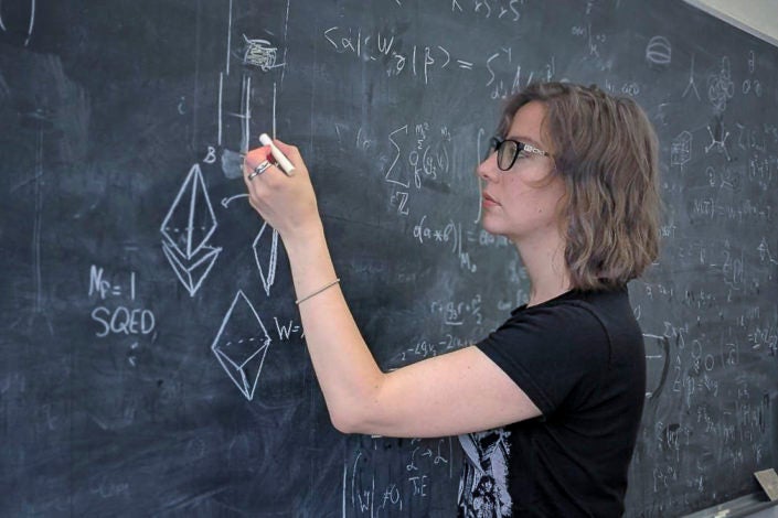 Physicist Natalie Paquette working at a chalkboard