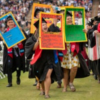 Graduating students parade in the Wacky Walk with signs