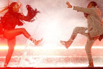 Two people dance in a puddle
