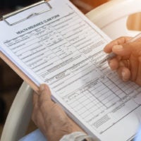 closeup of person filling out health insurance claim form