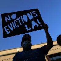 protestor with sign against evictions