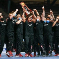 Cheering men holding trophy
