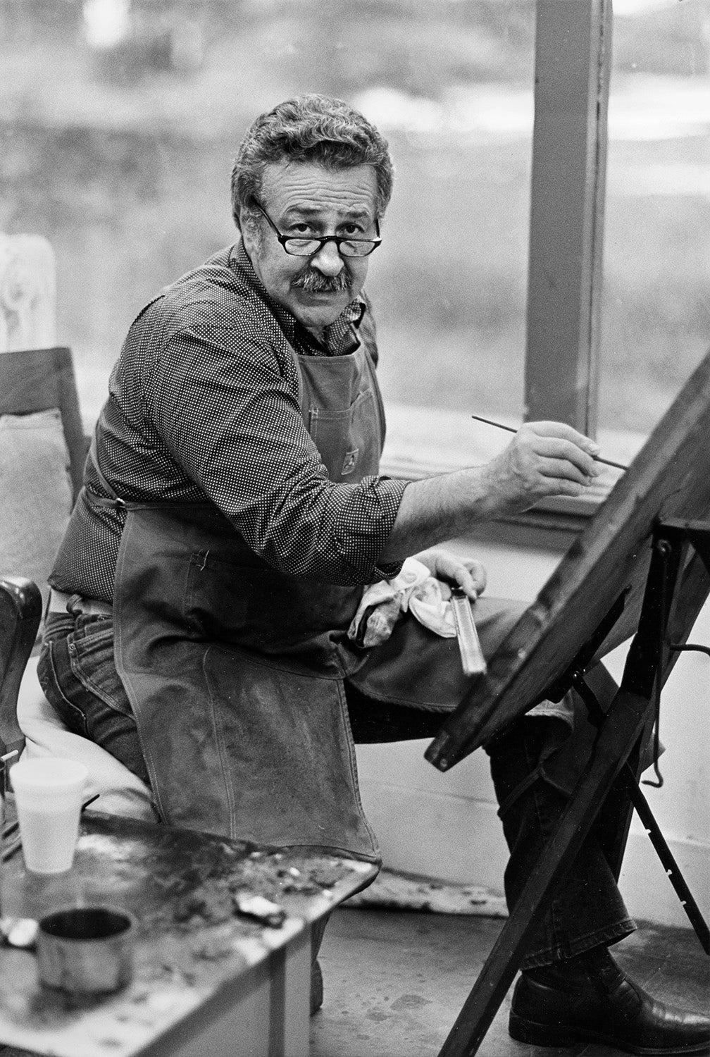 11/11/1983 Nathan Oliviera, professor of art, paints at his easel in his studio.