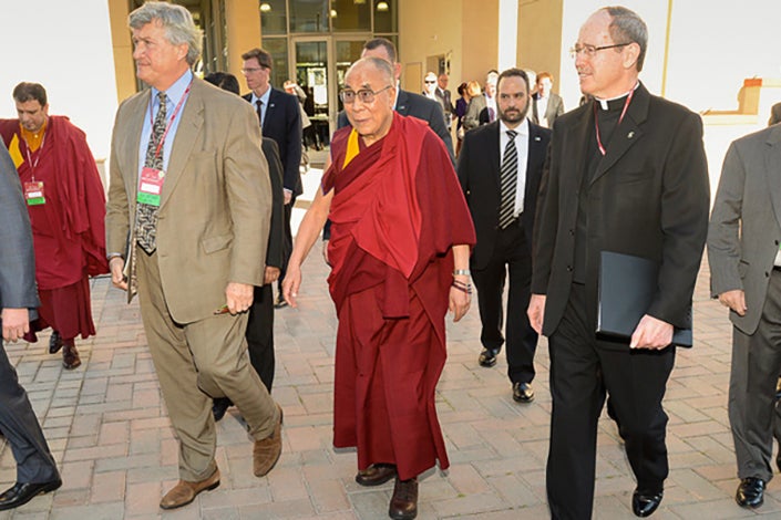 James Doty, left, director of Stanford's Center for Compassion and Altruism Research and Education, and the Rev. Michael Engh, right, president of Santa Clara University, escort the Dalai Lama to Monday's conference on commerce, ethics and compassion.