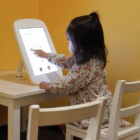 A child using a kiosk at the Children’s Discovery Museum of San Jose. Drawings from the kiosk were collected and analyzed using AI to help the researchers better understand how children perceive the world, and how they communicate those perceptions through drawing.